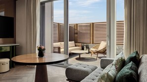 A modern living room with a round table, sofa, and chairs, large windows, and a TV. - Andaz Shanghai ITC (Shanghai)