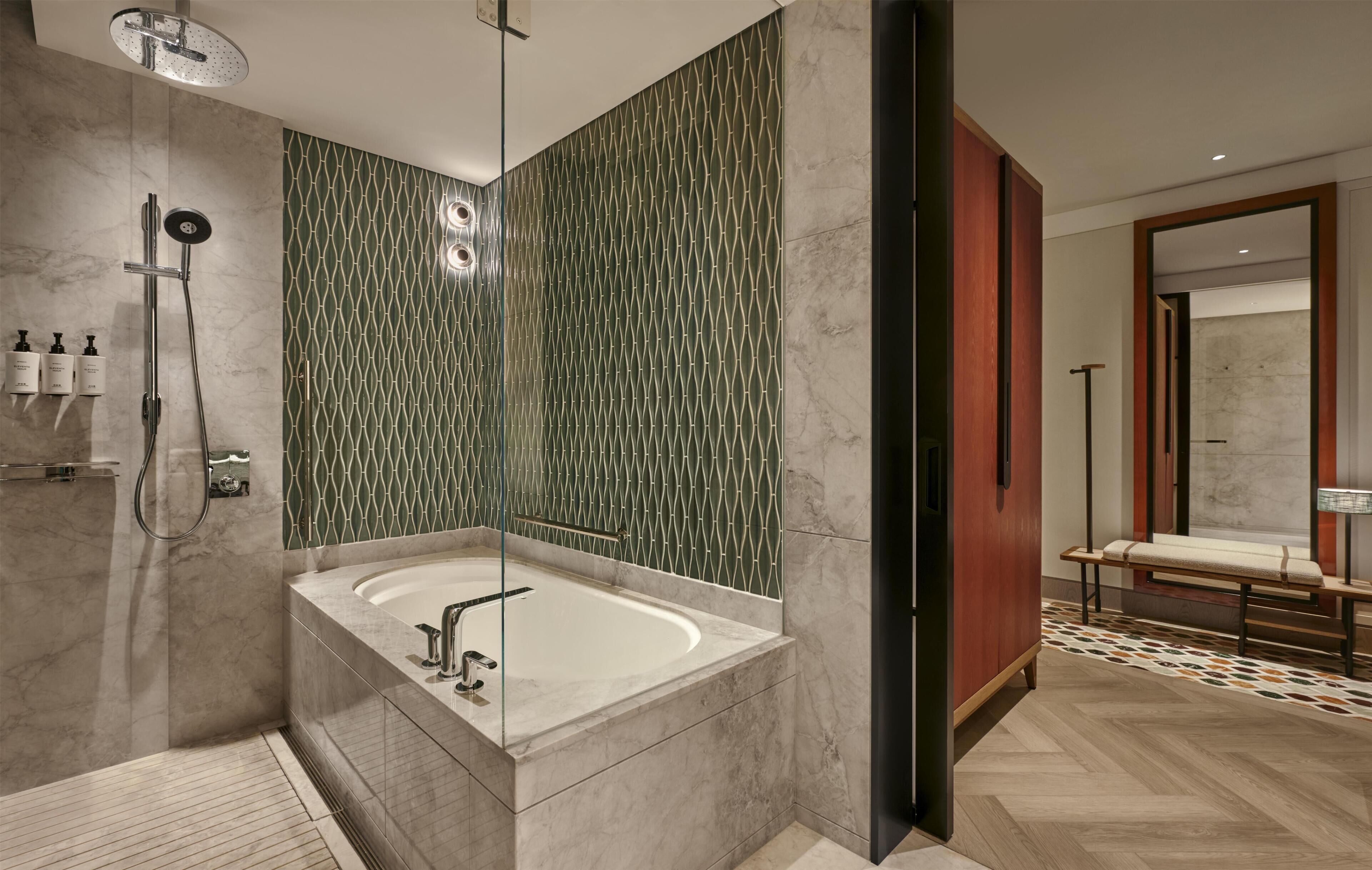 A modern bathroom with a freestanding bathtub, a shower area with a rain showerhead, and a vanity with a mirror.