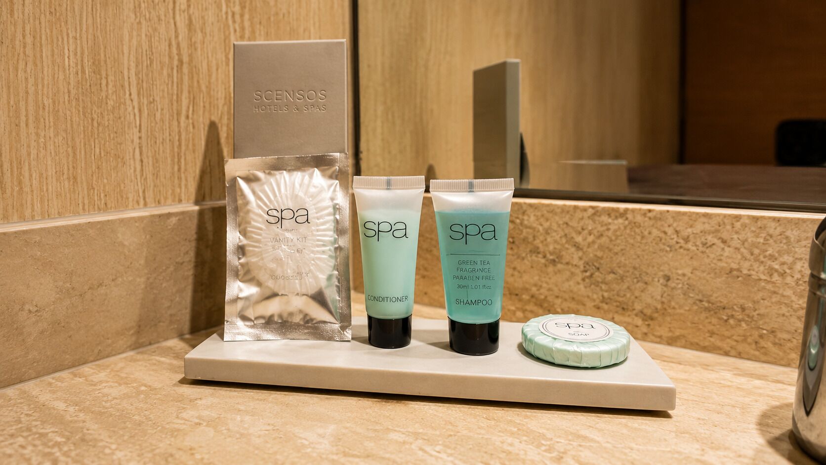 A spa kit with a conditioner, shampoo, and soap on a bathroom counter.