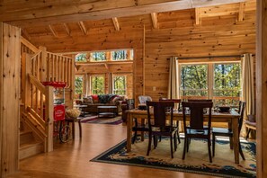 A wooden cabin interior with a dining area, sofa, and a popcorn machine. - Modern Asheville Cabin | Quiet & Peaceful Retreat (Fairview)