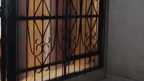 A gated area with a decorative metal fence and tiled flooring. - Alojamiento Olsi (Torreón)