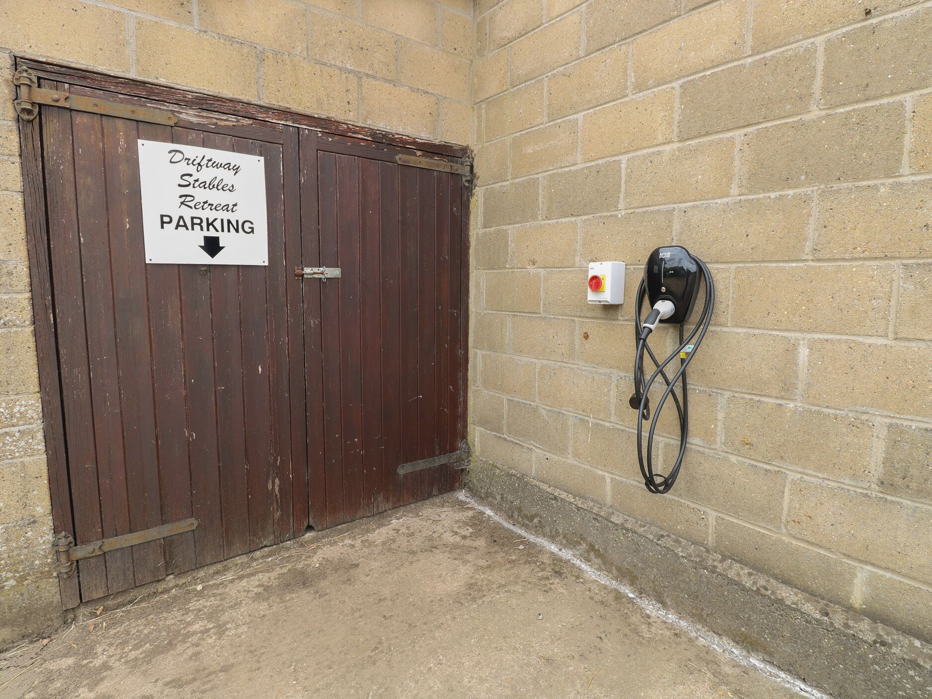 Eine Holztür mit einem Schild, das Parkplätze für den Driftway Stables Retreat anzeigt.