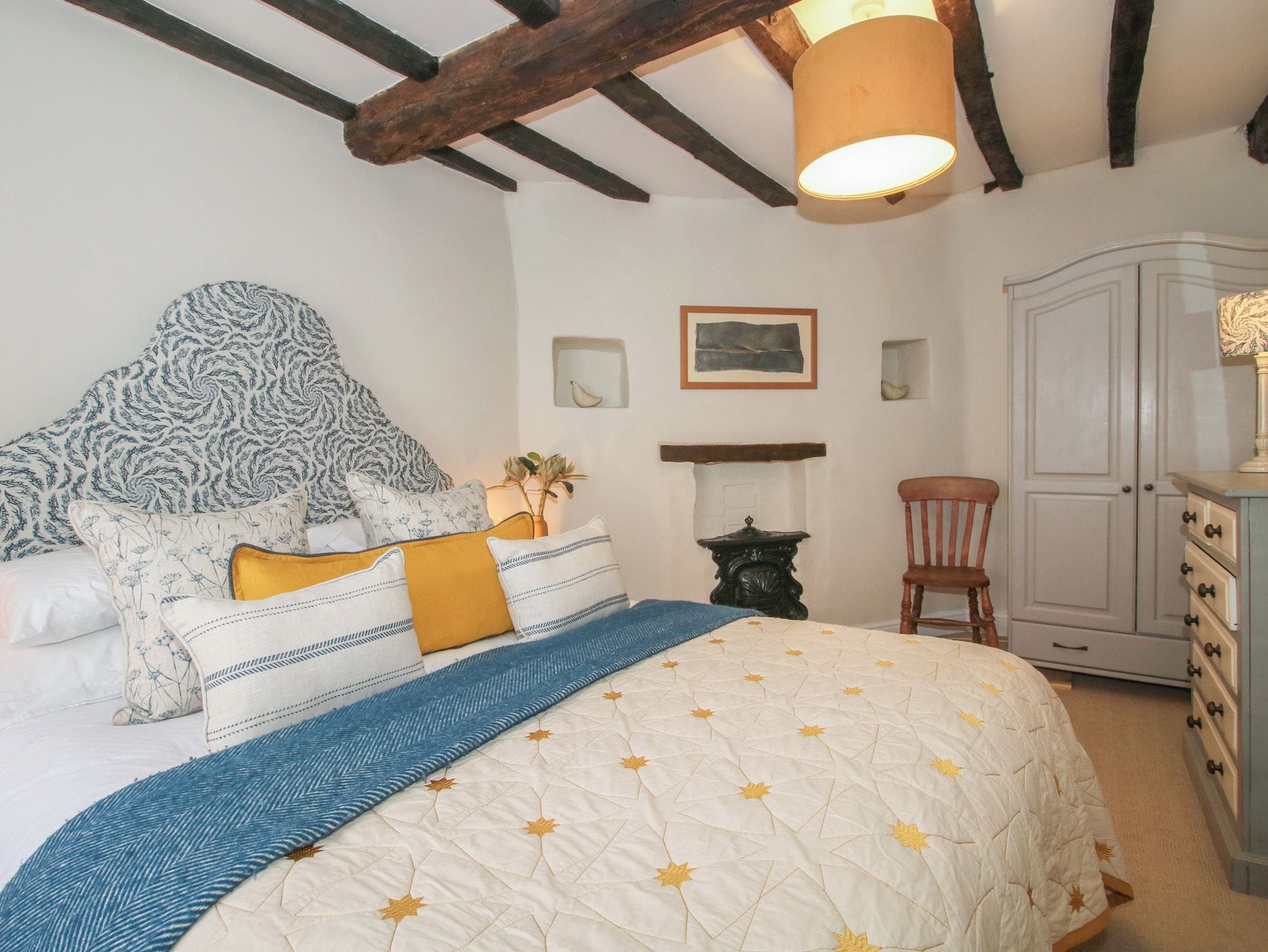A bedroom with a bed, a nightstand, a dresser, and a cabinet.