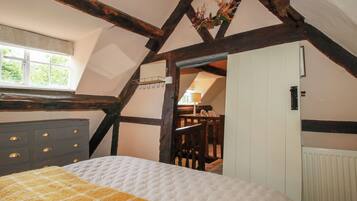 Un dormitorio con cama, cómoda, ventana y puerta que da a otra habitación.