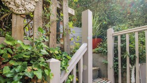 A wooden staircase with a white railing leading to a garden area. - 8 Welsh Street (Bishops Castle)