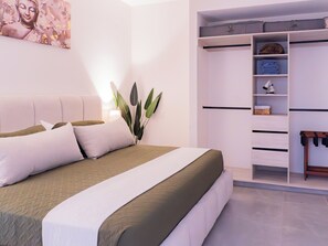 A bedroom with a bed, a bedside table, a lamp, a potted plant, and a wardrobe. - Apartment in Zona Dorada, 6 minutes from the beach, with a rooftop pool and barbecue (Mazatlán)
