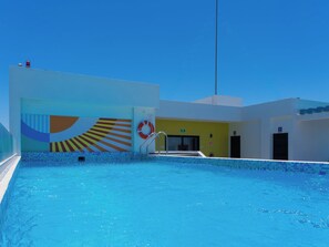 A swimming pool area with a lifebuoy, a door, and a staircase leading to an upper level. - Apartment in Zona Dorada, 6 minutes from the beach, with a rooftop pool and barbecue (Mazatlán)