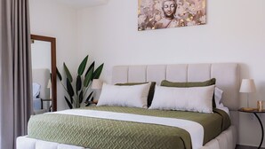 Une chambre à coucher moderne avec un grand lit, une tête de lit, une table de chevet, une lampe et une plante en pot.