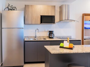 Eine moderne Küche mit einem Edelstahlkühlschrank, einer Mikrowelle und einer Kaffeemaschine.