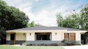 A single-story house with a front porch, a garage, and a well-maintained lawn. - Walton House (College Station)
