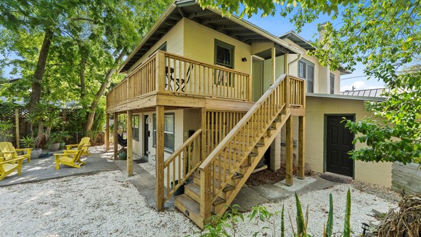 A two-story house with a wooden deck, a staircase, and outdoor seating. - Pet-Friendly Apt · Walk to Dwntwn ·Bikes & Parking (St. Augustine)