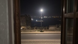 Nachtsicht aus einem Zimmer mit Blick auf eine Straße und entfernte Stadtlichter.