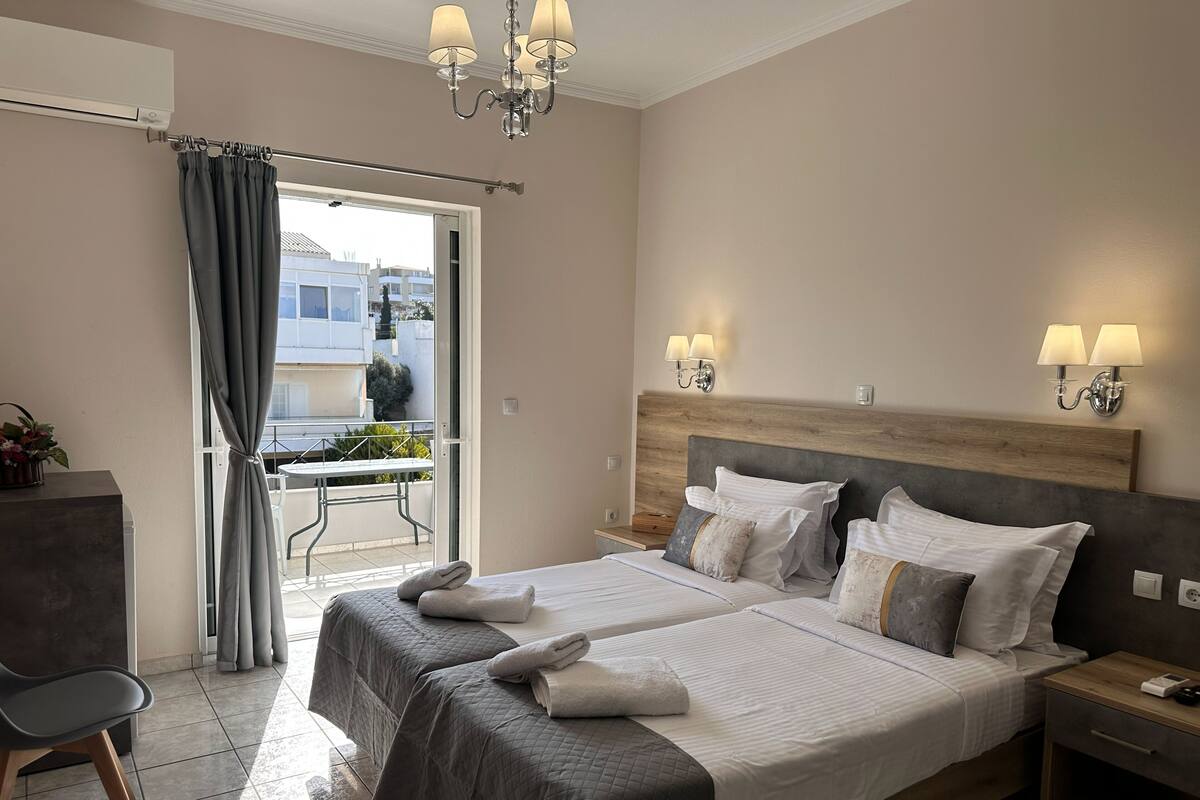 Ein Hotelzimmer mit Bett, Nachttischen, einem Schreibtisch und einem Balkon mit Blick.