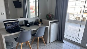 A modern kitchenette with a laptop, coffee maker, and two chairs. - Airport Suites Michelle (Spata-Artemida)