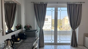 A modern room with a balcony, a kitchen counter, and a large mirror. - Airport Suites Michelle (Spata-Artemida)