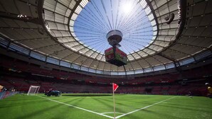 Un estadio con una gran cúpula central y un asta de bandera al frente.