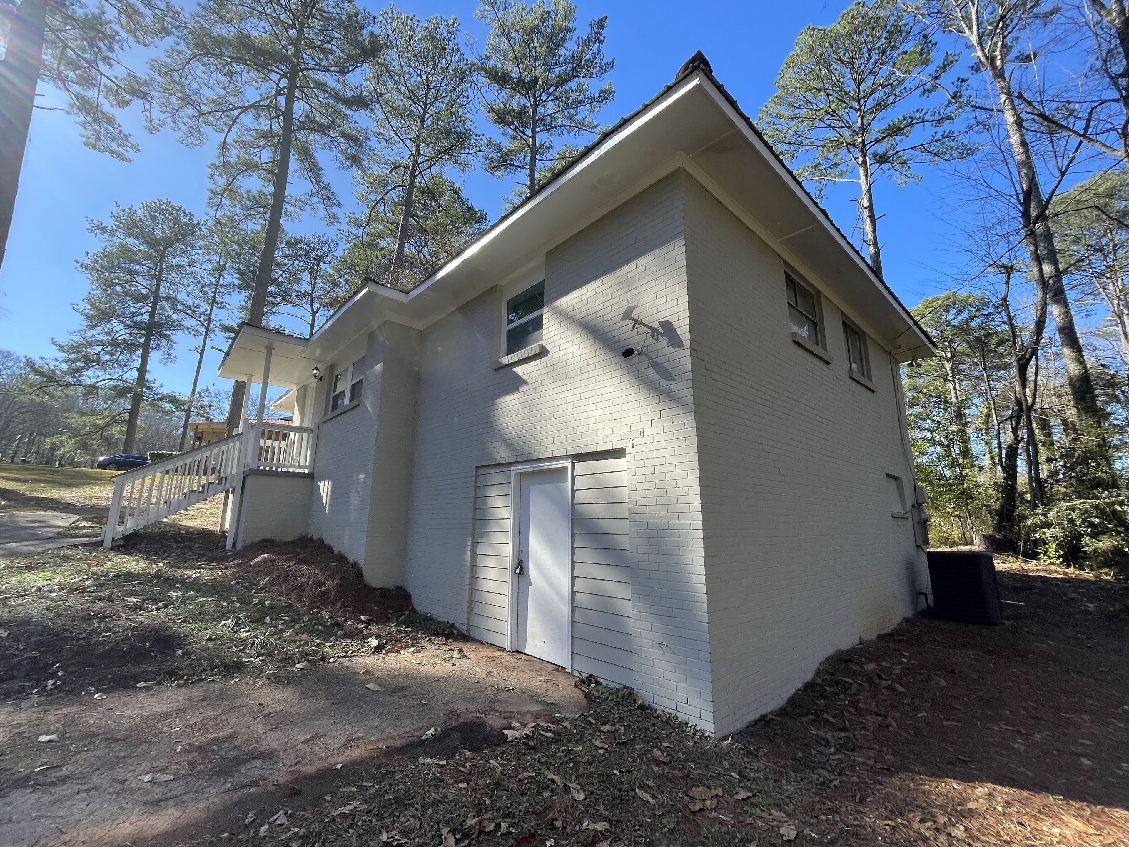 A single-story house with a white exterior, a garage door, and a small porch.