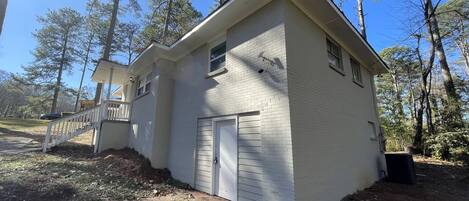 A single-story house with a white exterior, a garage door, and a small porch.