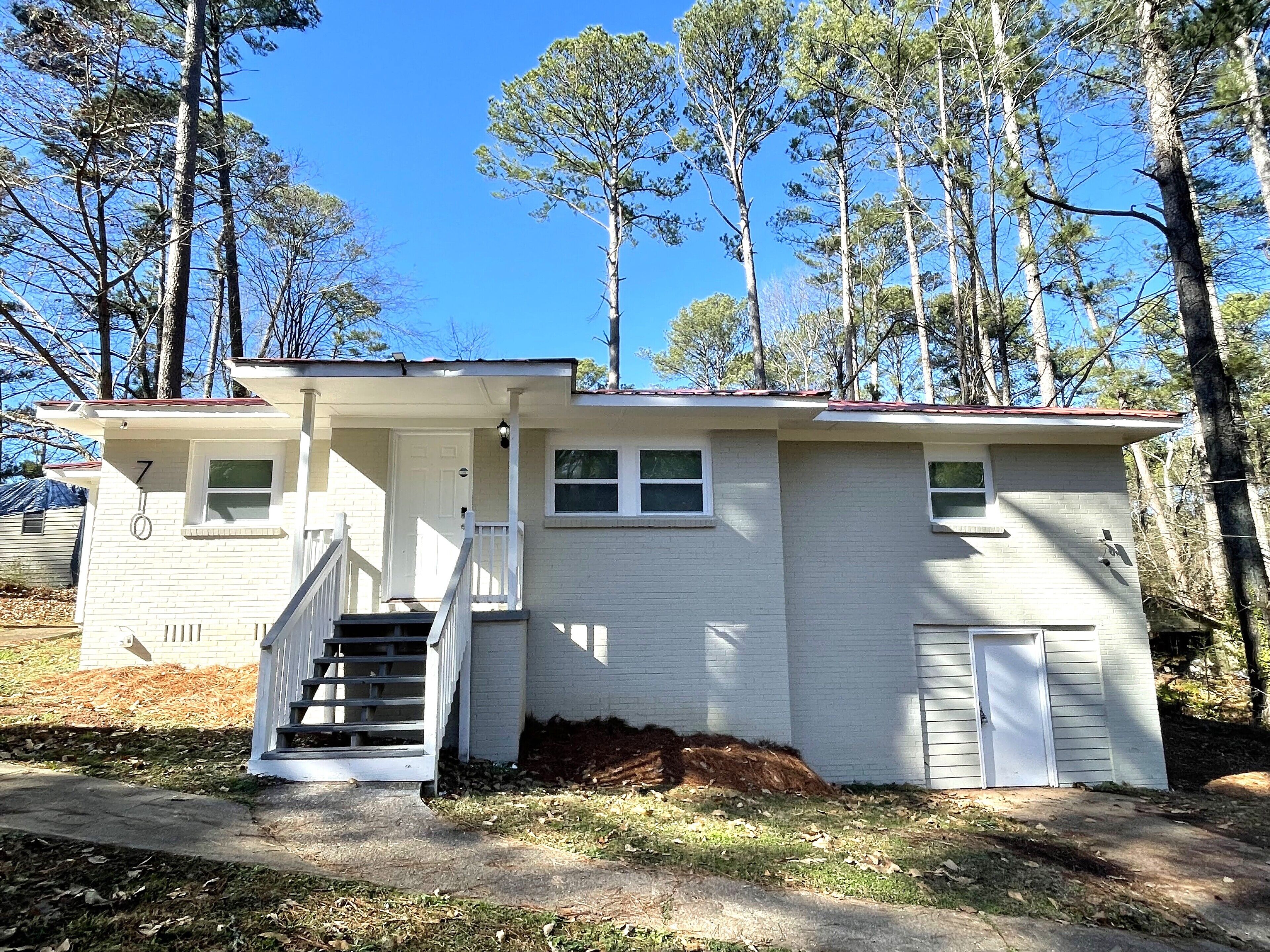 A single-story house with a front porch, a small staircase, and a garage.
