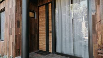 A wooden exterior with a sliding glass door and a black metal pillar.