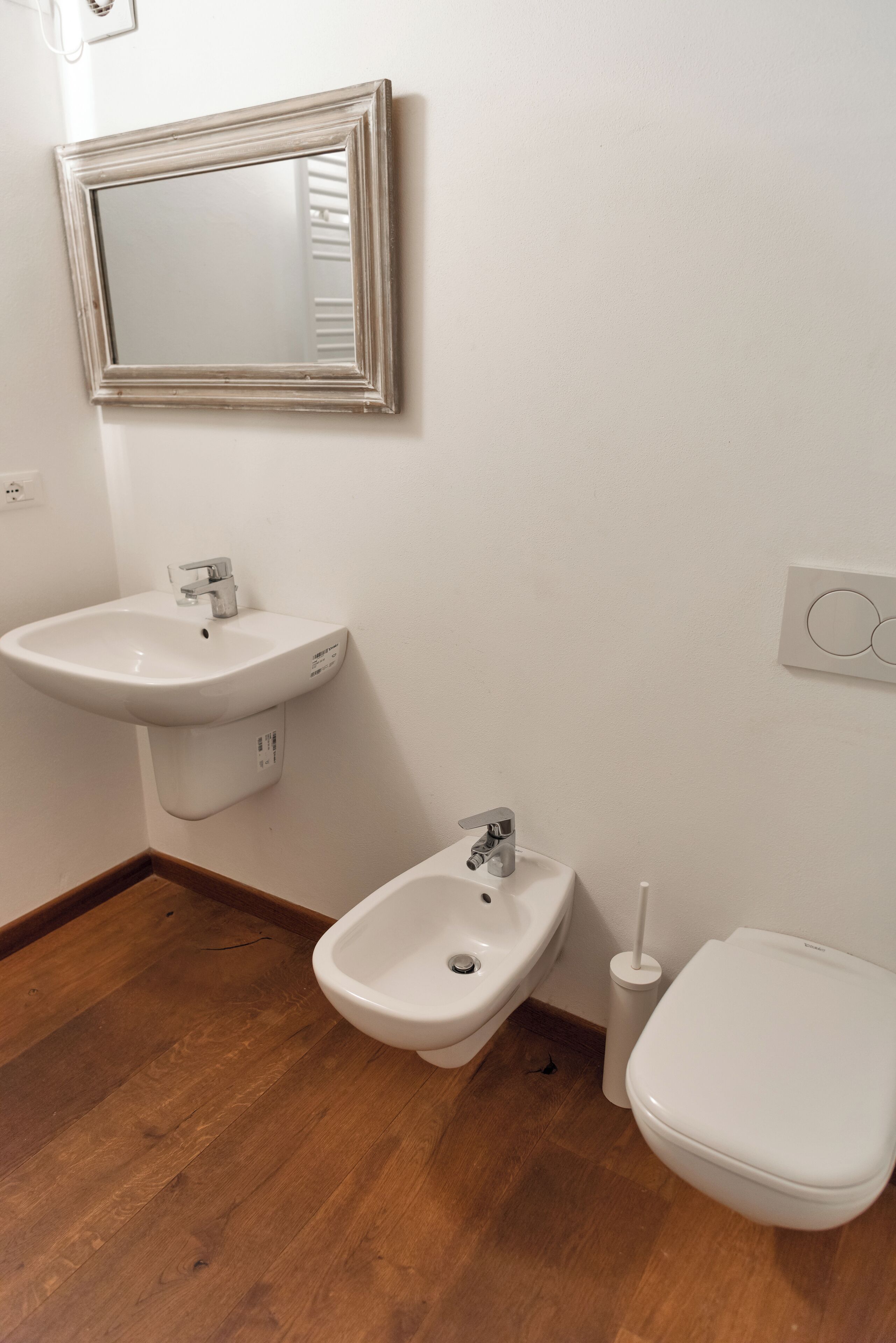 Une salle de bain avec un lavabo blanc, un bidet et des toilettes.