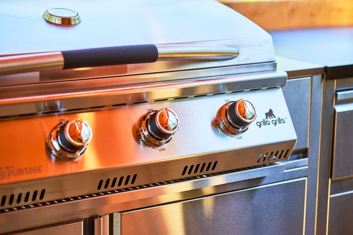 A stainless steel grill with three knobs, one labeled "OFF" and another "LOW".