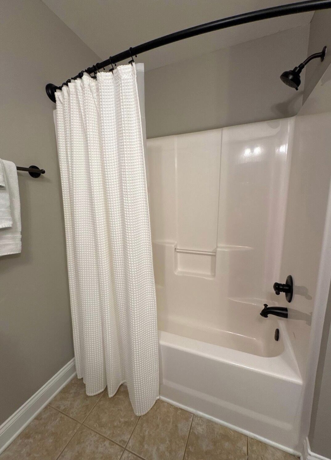 Une salle de bain avec une baignoire, un rideau de douche et un porte-serviettes.