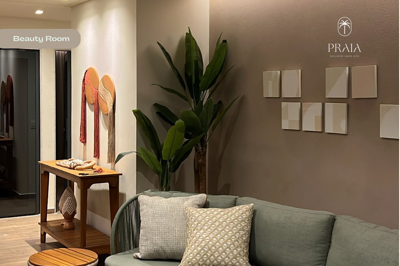 A modern beauty room with a green sofa, a wooden side table, and a large plant.