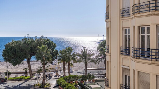 A beachfront hotel with a view of the sea, palm trees, and a promenade. - Villa Royale - Luxurious 3 bedrooms near Croisette (Cannes)