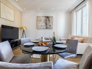 Ein Essbereich mit einem runden Tisch, Stühlen und einem Fernseher.