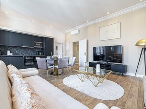 Ein modernes Wohnzimmer mit einer Couch, einem Couchtisch und einem Fernseher.