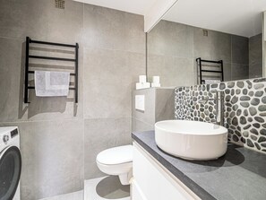 A modern bathroom with a large mirror, a round sink, and a built-in washing machine. - One-bedroom apartment – ​​Parking and near beach (Cannes)