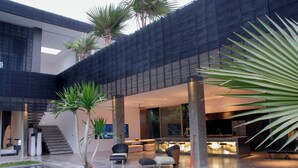 Ein modernes Haus mit geräumiger Terrasse, einem Pool und Küchenbereich.