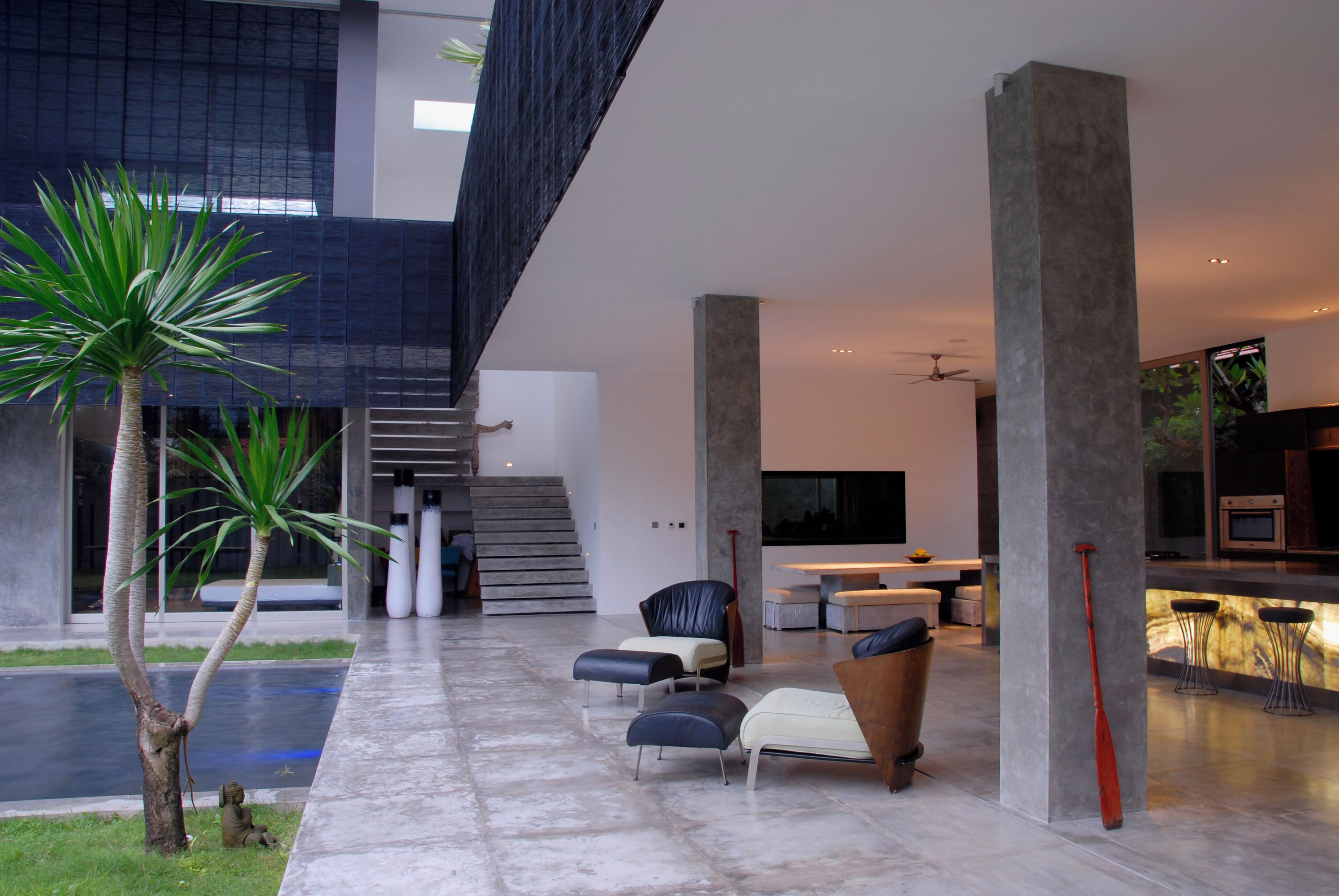 Un intérieur moderne comprenant un coin salon, un escalier et une cuisine.