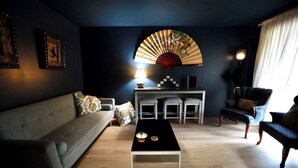 Una sala de estar moderna con un sofá, una mesa de centro, un ventilador y una silla.