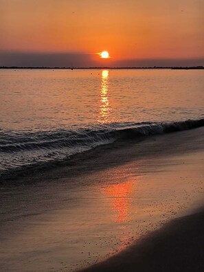 A sunset over a calm sea with gentle waves on a sandy beach. - Cozy studio 50 meters from the Atlantic Ocean   (La Baule-Escoublac)