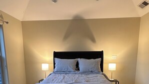 Una camera da letto con un letto, due lampade da comodino e una finestra.