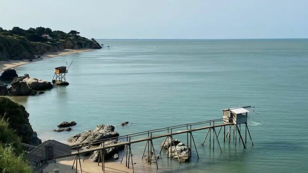 A coastal view with a wooden pier leading to a lifeguard tower and a sandy beach. - Villa, close to beaches (Pornic)