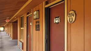 A row of hotel rooms with wooden paneling and numbered doors. - River Ranch  Oasis /  Wild West Escape (River Ranch)