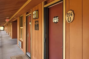 A row of hotel rooms with wooden paneling and numbered doors. - River Ranch  Oasis /  Wild West Escape (River Ranch)