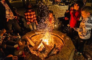 A group of people around a campfire at night.