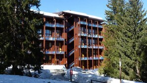 A multi-story hotel with balconies, surrounded by snow and trees. - 100m from ski slopes, 2nd floor, tv, 30m², Les Arcs (Les Arcs)