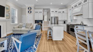 A modern kitchen with white cabinetry, a central island, and a stainless steel refrigerator. - Brand new, beach block, 3bedroom 2 bath duplex! (Ocean City)