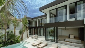 A modern house with a pool, outdoor seating, and large windows. - Ultra-Luxe 4BR Seminyak Villa | Enclosed AC Living & Private Pool (Seminyak)