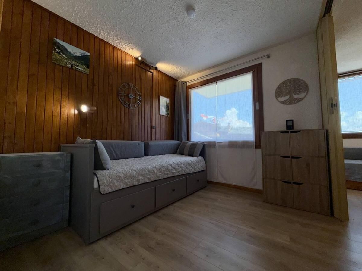 Una habitación con paredes de madera, un sofá, un armario y una ventana con vistas.