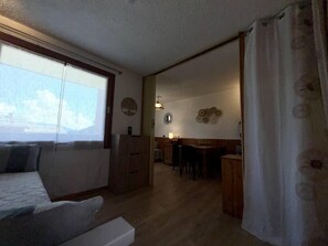 A cozy living room with a sofa, a dining area with a table and chairs, and a kitchen area with cabinets. - 50m from shops, 1st floor, balcony, tv, ski locker, 24m², Valmorel (Valmorel)