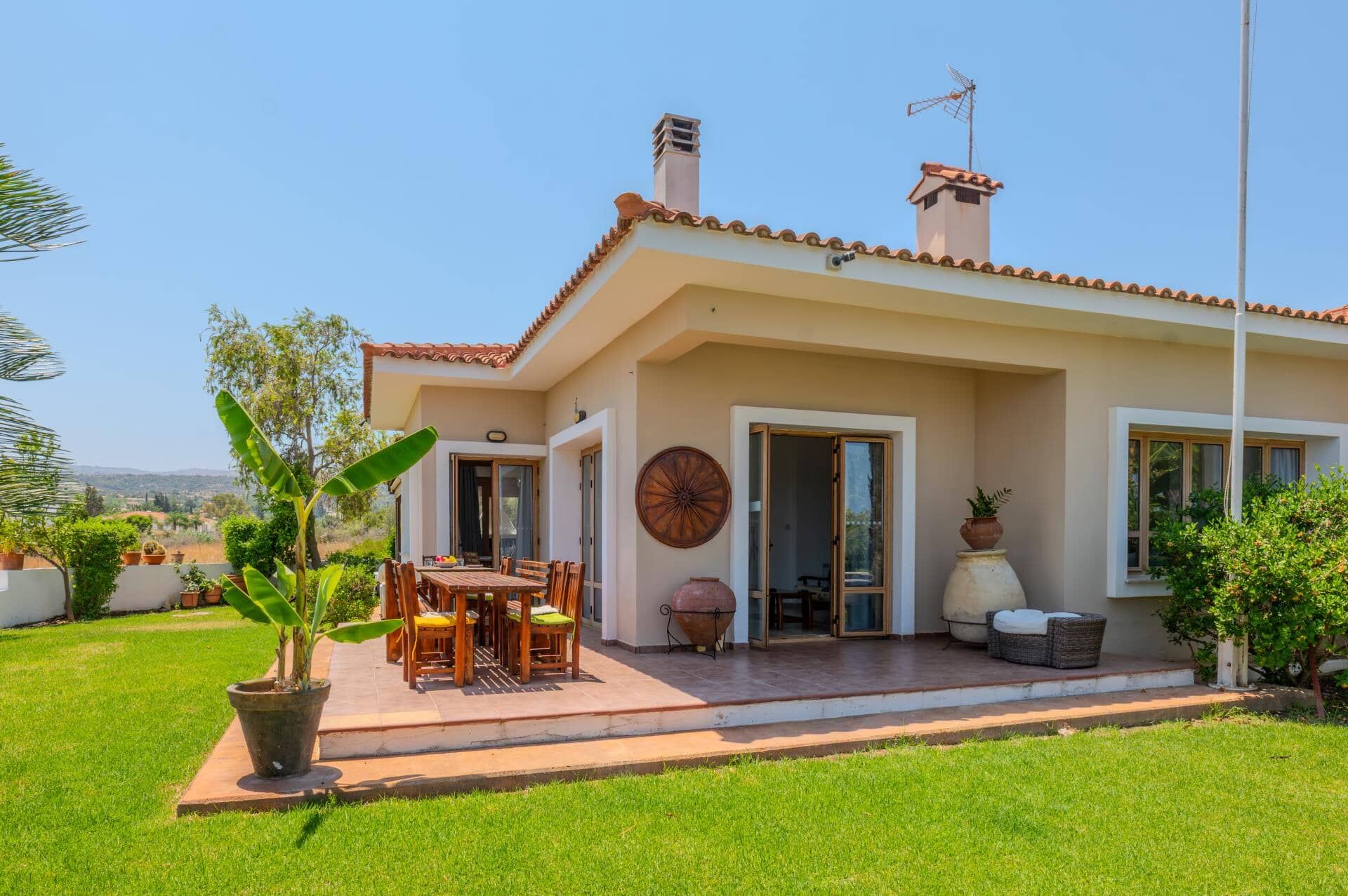 Une maison avec un patio, une table à manger et des chaises.