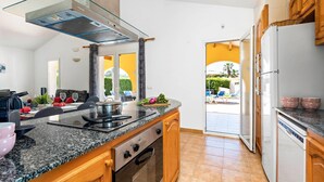 A modern kitchen with granite countertops, a stainless steel range hood, and a built-in oven. - Villa Marte by Villa Plus (Cap d'Artrutx)