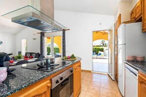 A modern kitchen with granite countertops, a stainless steel range hood, and a built-in oven. - Villa Marte by Villa Plus (Cap d'Artrutx)