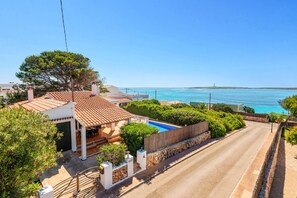 A coastal property with a swimming pool, a view of the sea, and a clear sky. - Villa S'Escaleta by Villa Plus (Punta Prima)